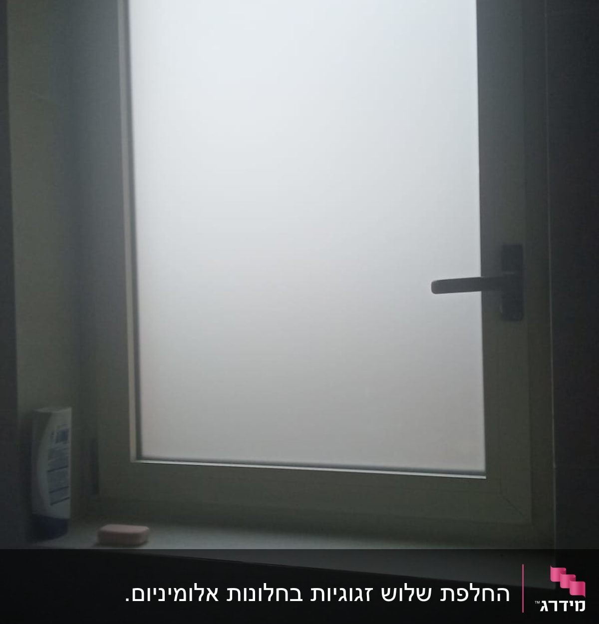 חלון זכוכית חלבית עם מסגרת לבנה וידית שחורה